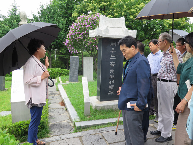 ▲ 양화진외국인선교사묘원 내 셔우드 홀 선교사의 묘비 앞에서 안내를 받고 있다.